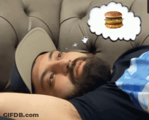 Bearded Man Laying On Couch With Hamburger In Thought Bubble GIF