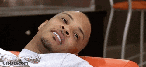 Bearded Man Laying On Red Couch Smiling GIF