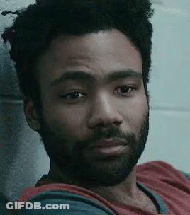 Bearded Man Leaning Against Brick Wall GIF
