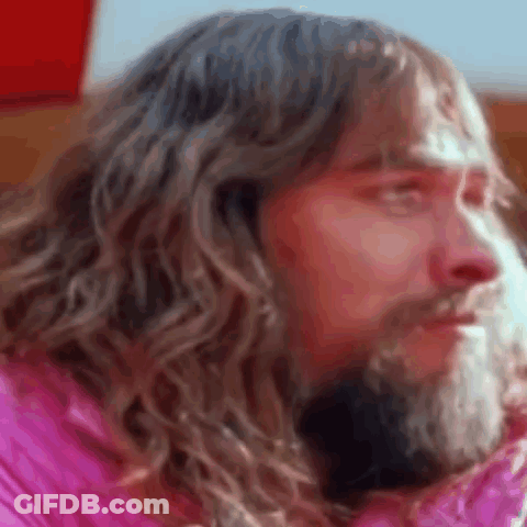 Bearded Man Long Hair Pink Jacket Looking Camera GIF