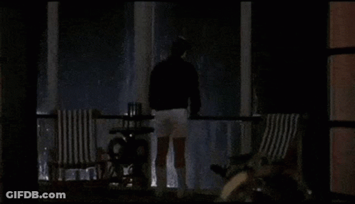 Bearded Man Looking At Camera In Dark Room GIF