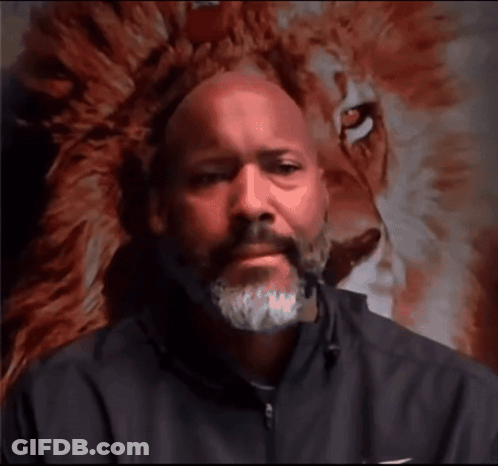 Bearded Man Looking At Camera In Front Of Lion Painting GIF
