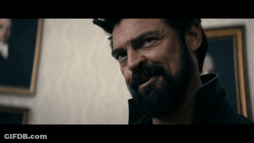 Bearded Man Looking At Camera In Front Of Painting GIF
