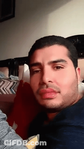 Bearded Man Looking At Camera On Bed GIF