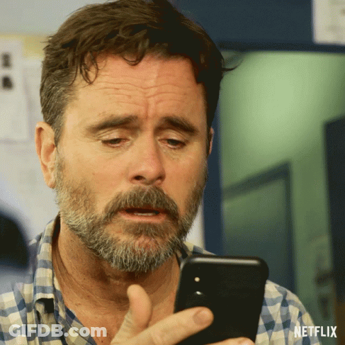Bearded Man Looking At Phone With Netflix Logo GIF