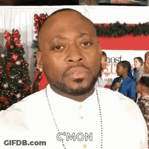 Bearded Man Making Funny Face In Front Of Christmas Tree GIF