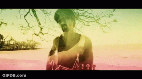 Bearded Man On Beach With Rainbow Background GIF
