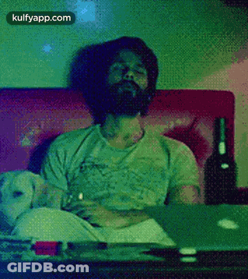 Bearded Man On Couch With Wine And Laptop GIF