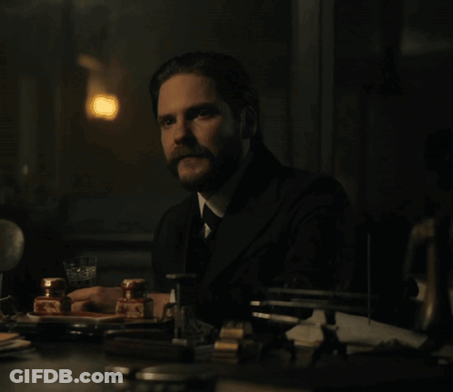 Bearded Man Sits At Table GIF