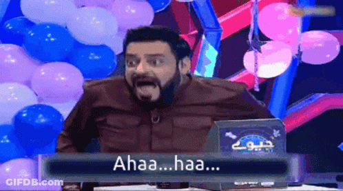 Bearded Man Sitting At Table With Balloons Saying Ahaa Haa GIF