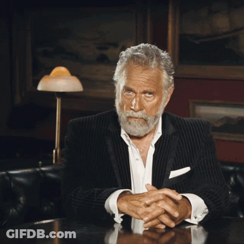 Bearded Man Sitting At Table With Folded Hands GIF