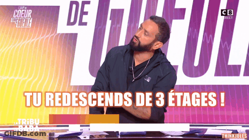 Bearded Man Sitting By Sign Tu Redescents De 3 Etages GIF
