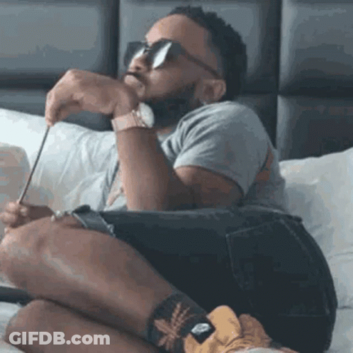 Bearded Man Sitting Cross-Legged On Bed GIF