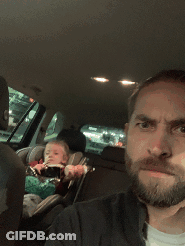 Bearded Man Sitting In Car With Baby In Car Seat GIF