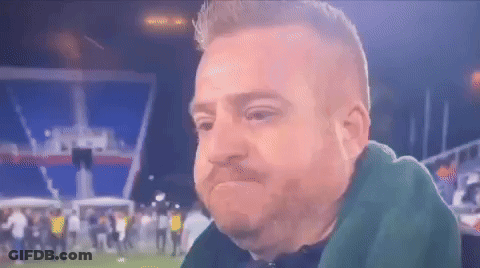 Bearded Man Sitting In Front Of Crowd On Soccer Field GIF