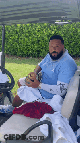 Bearded Man Sitting In Golf Cart Holding Soda GIF