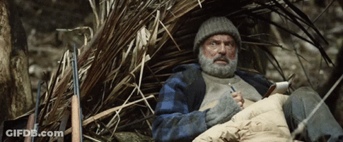 Bearded Man Sitting In Pile Of Branches GIF