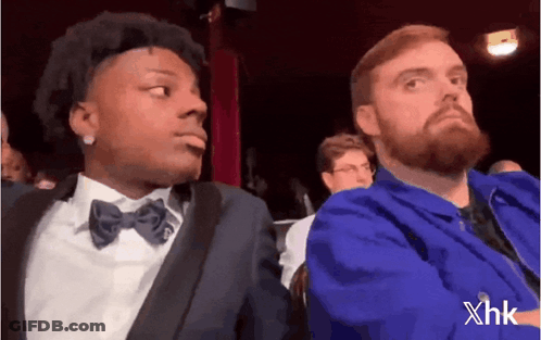 Bearded Man Sitting Next To Man In Suit And Bow Tie GIF