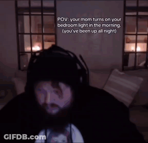 Bearded Man Sitting On Couch In Dark Room GIF