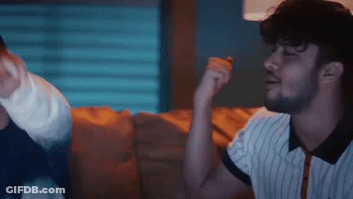 Bearded Man Sitting On Couch Talking To Another Man GIF