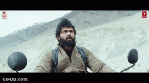Bearded Man Sitting On Motorcycle In Desert GIF