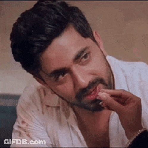 Bearded Man Sitting With Hand On Chin GIF