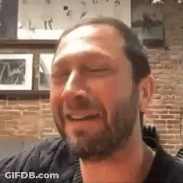 Bearded Man Smiling Eyes Closed In Brick Wall Room GIF