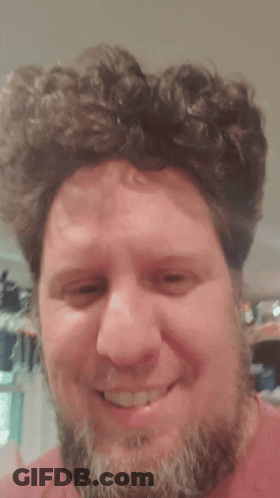 Bearded Man Smiling In Front Of Cat Curtain GIF