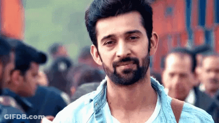 Bearded Man Smiling In Front Of Crowd GIF