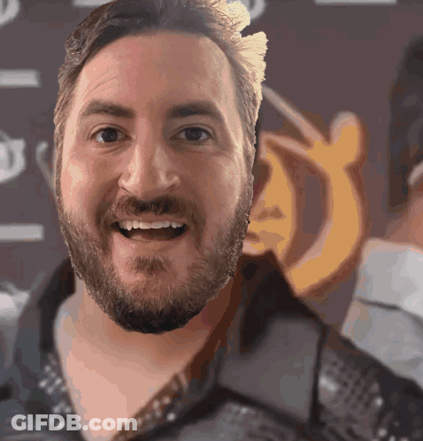 Bearded Man Smiling In Front Of Sign Saying A GIF