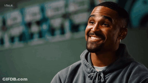 Bearded Man Smiling Next To S.s.a.j. Wall GIF