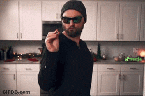 Bearded Man Smoking Cigarette In Kitchen GIF