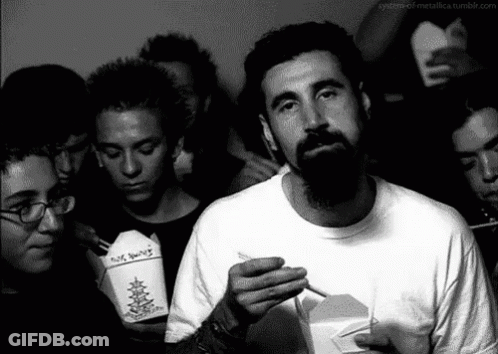 Bearded Man Smoking While Holding No Smoking Box GIF