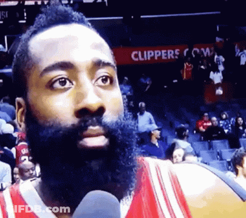 Bearded Man Speaking Into Microphone Beside Clippers Sign GIF