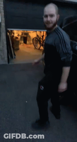 Bearded Man Squatting In Front Of Bike GIF