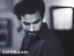 Bearded Man Standing In Dark Room GIF