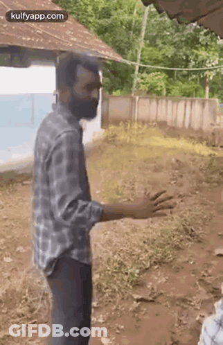 Bearded Man Standing In Dirt In Front Of House GIF