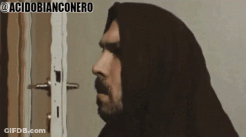 Bearded Man Standing In Front Of Door Wearing Hood GIF