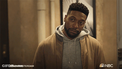 Bearded Man Standing In Front Of New Amsterdam Sign GIF
