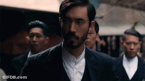 Bearded Man Standing In Line With Men In Suits GIF