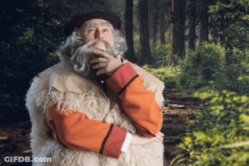 Bearded Man Standing In Woods Hand On Chin GIF