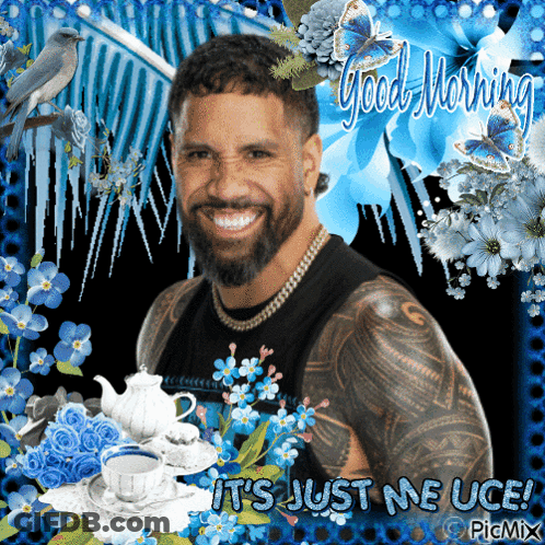Bearded Man Surrounded By Blue Flowers Saying Good Morning GIF