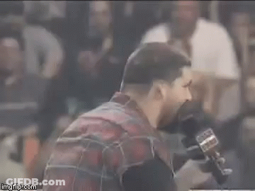 Bearded Man Talking Into Microphone In Crowded Stadium GIF