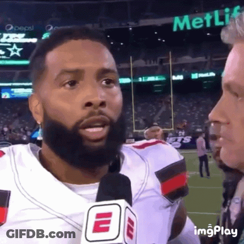 Bearded Man Talking Into Microphone With MetLife Sign GIF