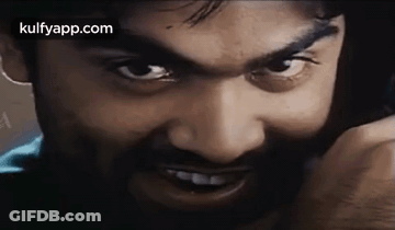 Bearded Man Talking On Cell Phone Looking At Camera GIF