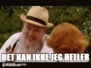 Bearded Man Talking To Redhead Woman Holding Pipe GIF