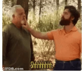 Bearded Man Touching Another Man's Nose In Forest GIF