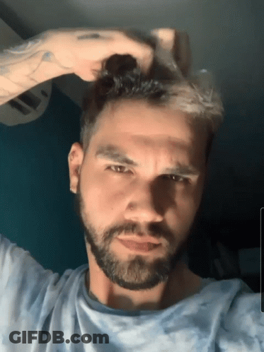 Bearded Man Touching Hair Looking At Camera GIF