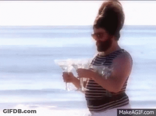 Bearded Man Walking On Beach With Martini Glass GIF