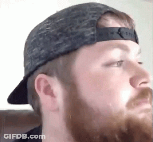 Bearded Man Wearing Hat Looks At Camera GIF